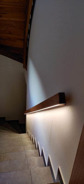 Integrierte LED-Handlaufbeleuchtung entlang eines Holzhandlaufs im Treppenhaus