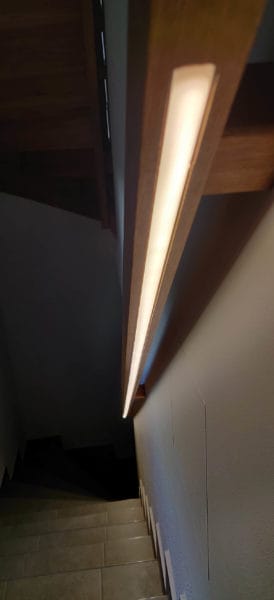 Integrierte LED-Handlaufbeleuchtung entlang eines Holzhandlaufs im Treppenhaus