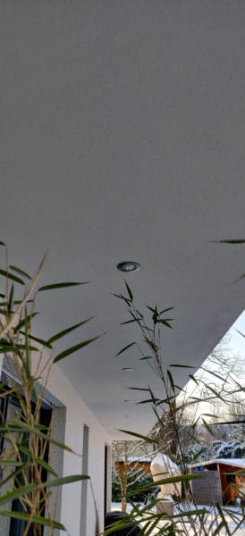 Eingelassene LED-Deckenspots an einer überdachten Terrasse mit Blick in den winterlichen Garten
