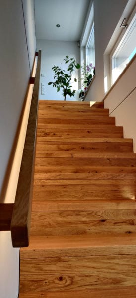 Holztreppe mit indirekter LED-Beleuchtung im Einfamilienhaus, installiert von SHI