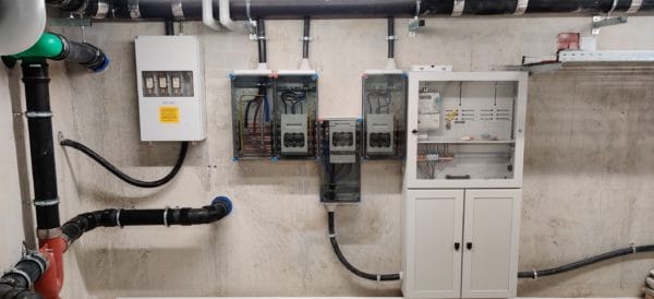 Technikraum mit Hausanschlusskasten, Zählerfeldern und transparenter Hauptverteilung; von SHI Gebäudetechnik sauber montierte Energiekabel und Sammelschienen.