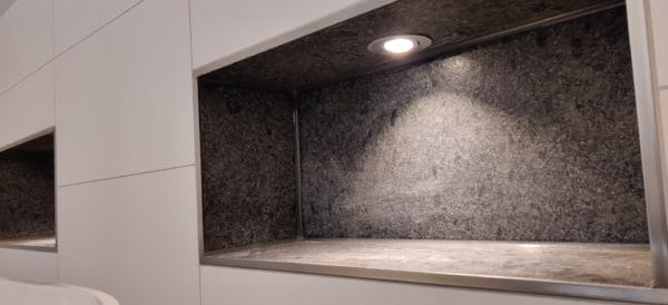 zwei von SHI Gebäudetechnik beleuchtete Wandnischen mit warmweißen LED-Spots.