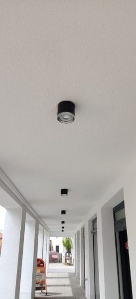 In Reihe montierte schwarze LED-Deckenspots unter einem Arkadengang, installiert von SHI Gebäudetechnik im Humboldt Palais.