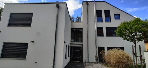 Außenansicht eines modernen Einfamilienhauses in Dachau mit grauer Putzfassade.