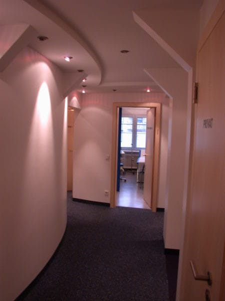 Modern beleuchteter Praxisflur mit abgehängter Decke und Spots in der Arztpraxis Dr. Naumann