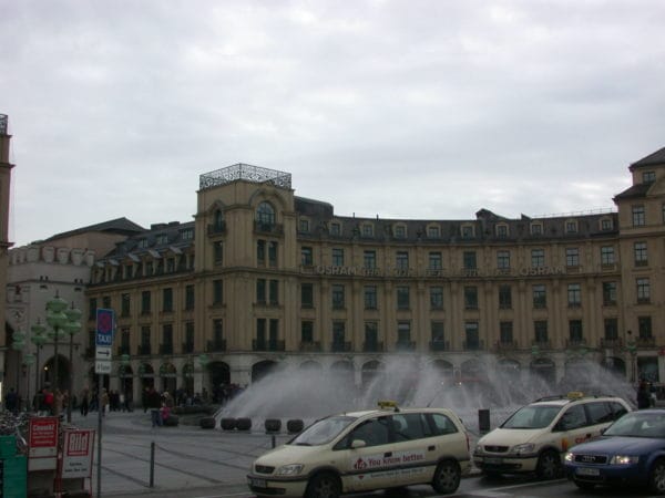 Karlsplatz/Stachus in München mit Springbrunnen, Osram-Haus und wartenden Taxis im Vordergrund