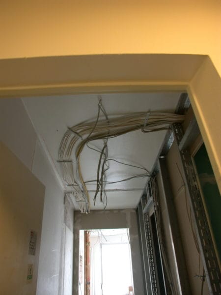 Kabelbündel und Leitungsführung in der Zwischendecke eines Flurs während der Elektroinstallation.