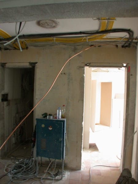 Offener Leitungsschacht mit gelben und weißen Kabeln neben Fenster – Elektroinstallation Praxis Dr. Naumann