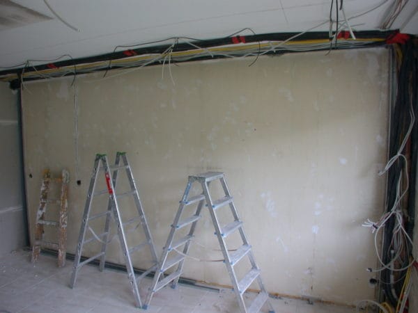 Innenraum mit drei Leitern; offene Kabeltrassen und Leitungsbündel unter der Decke – Elektroinstallation Praxis Dr. Naumann