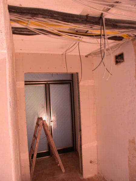 Offene Deckenverkabelung mit Kabelbündeln über dem Türbereich im Flur – Praxis Dr. Naumann