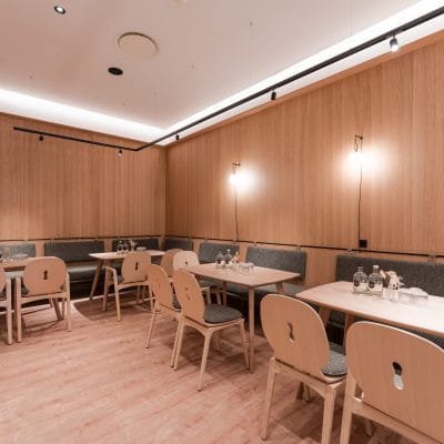Separater Gastraum mit moderner Lichtinstallation und Holzwänden im Hotel Zeller’s Quartier Königsbrunn, umgesetzt von SHI Gebäudetechnik GmbH