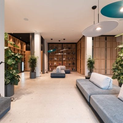 Moderne Lobby mit Designbeleuchtung, Loungemöbeln und Bücherregal im Hotel Zeller’s
