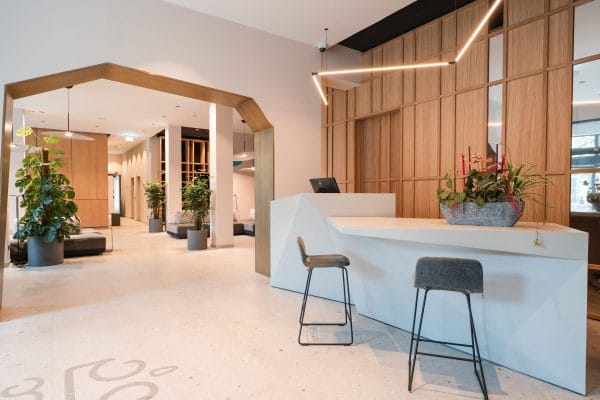 Moderner Empfangsbereich mit Design-Rezeption, Sitzgelegenheiten und Beleuchtung im Hotel Zeller’s Quartier Königsbrunn – Elektro- und Lichtinstallation von SHI Gebäudetechnik GmbH