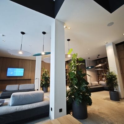 Heller Lounge-Bereich im Hotel Zeller Königsbrunn mit Deckenspots, Designleuchten und Smart Building Technik von SHI Gebäudetechnik