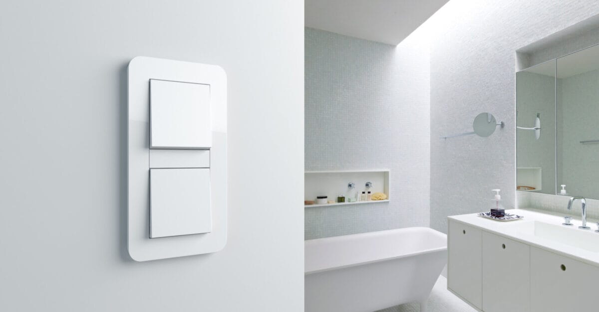 Weißer Lichtschalter mit zwei Wippen an der Wand im modernen Badezimmer